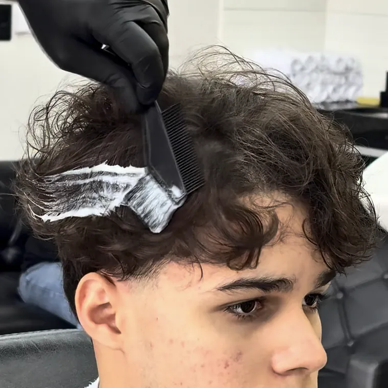 Cliente jovem com cabelo cacheado recebendo o produto com pente