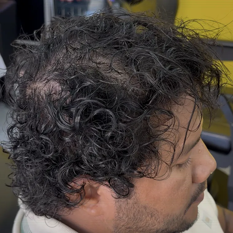 Cliente com cabelo cacheado e fechado na cadeira