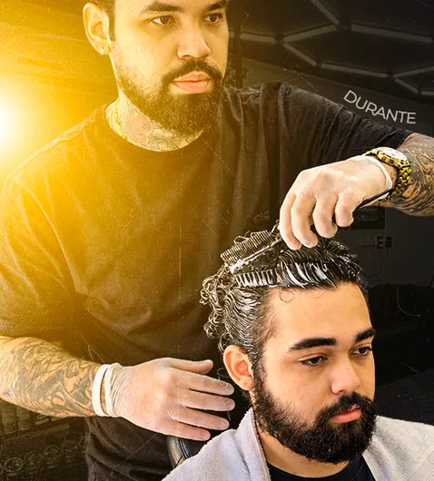 Barbeiro aplicando o produto mecha a mecha com pente
